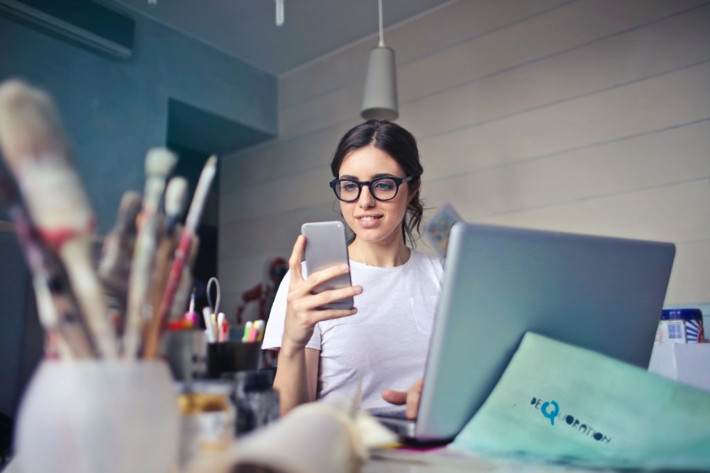 Our 13 Top Secret Image SEO Tips That Everyone Should Follow. Woman looking at phone with glasses on.